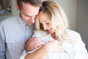 mom and dad looking at newborn baby