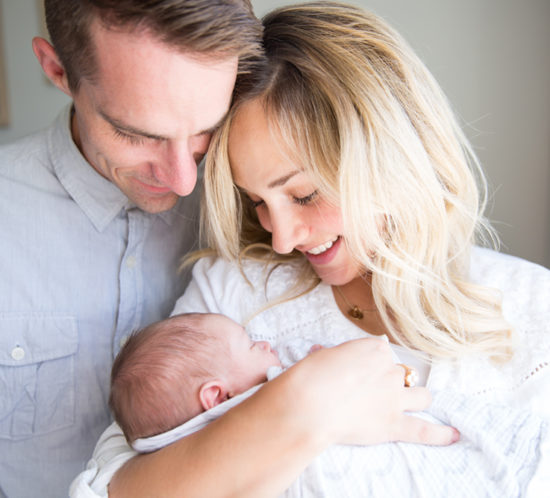 mom and dad looking at newborn baby