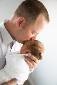 dad kissing newborn head