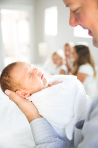 family with newborn on bed in home photography