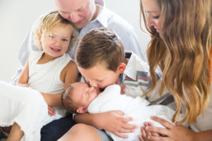 family with newborn on bed in home photography