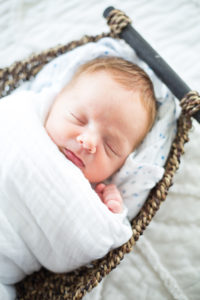 newborn on bed in basket