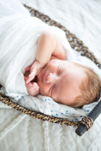 newborn on bed in basket