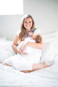 mom with newborn on bed in home photography