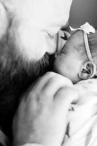 dad snuggling newborn baby