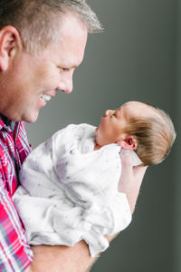 dad holding newborn looking at each other