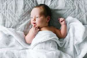 newborn photography on bed with blanket