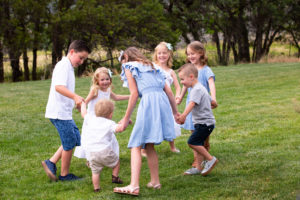 grandkids playing ring around the rosy on grass