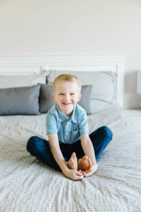 little boy portrait sitting on the bed