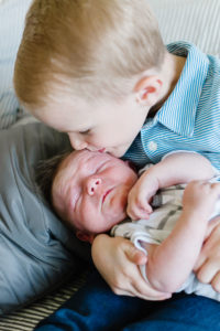oldest brother kissing baby brother's head
