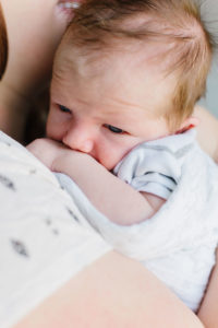 newborn baby boy snuggling with his mom