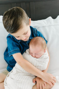 brother holding newborn baby brother