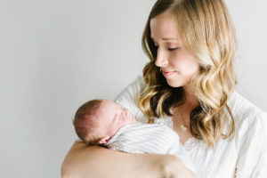 mom holding and looking at newborn baby boy