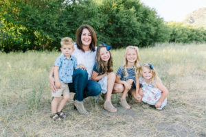 Grandma and granddaughters showing off their shoes with grandson photobombing