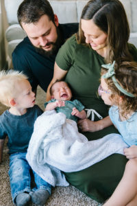 Family all looking at newborn baby boy
