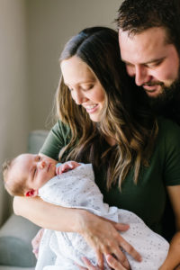 Mom and dad holding and looking at newborn baby brother