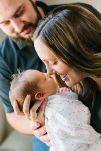 Mom nuzzling newborn baby boy's nose