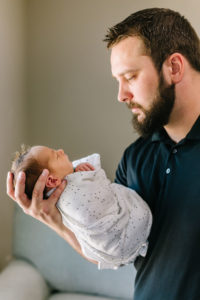 Dad holding and looking at newborn baby boy