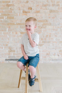 little boy sitting on a stool