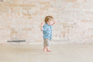 one year old walking toward window